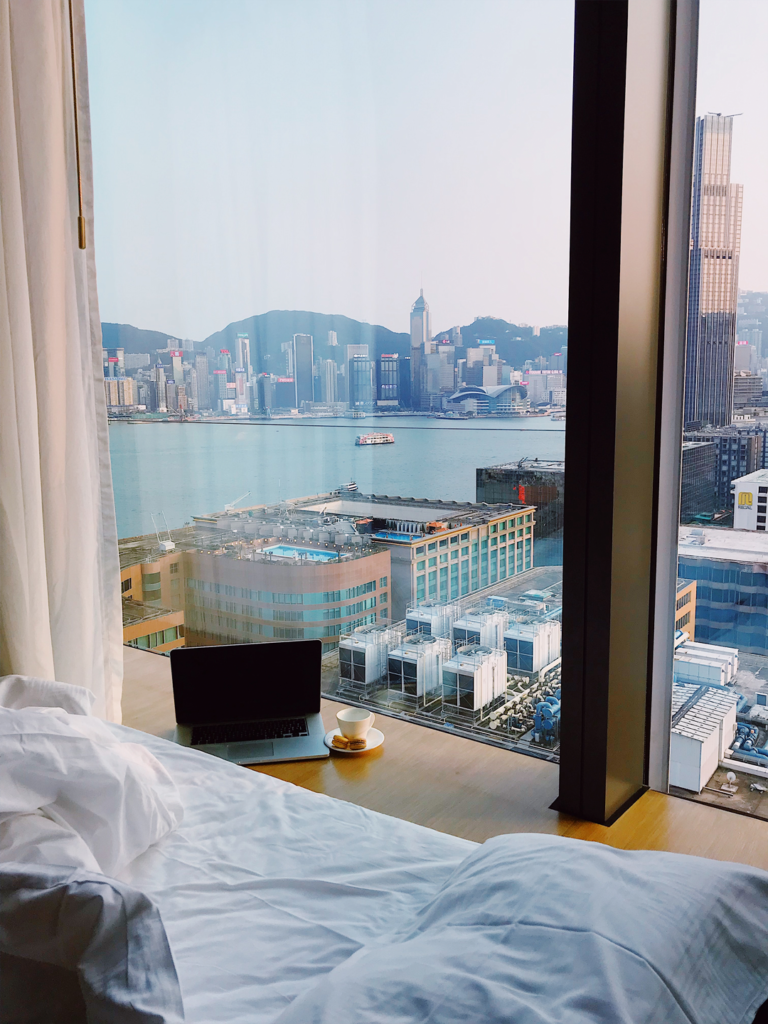 view form a business travel hotel room window with a laptop overlooking a city