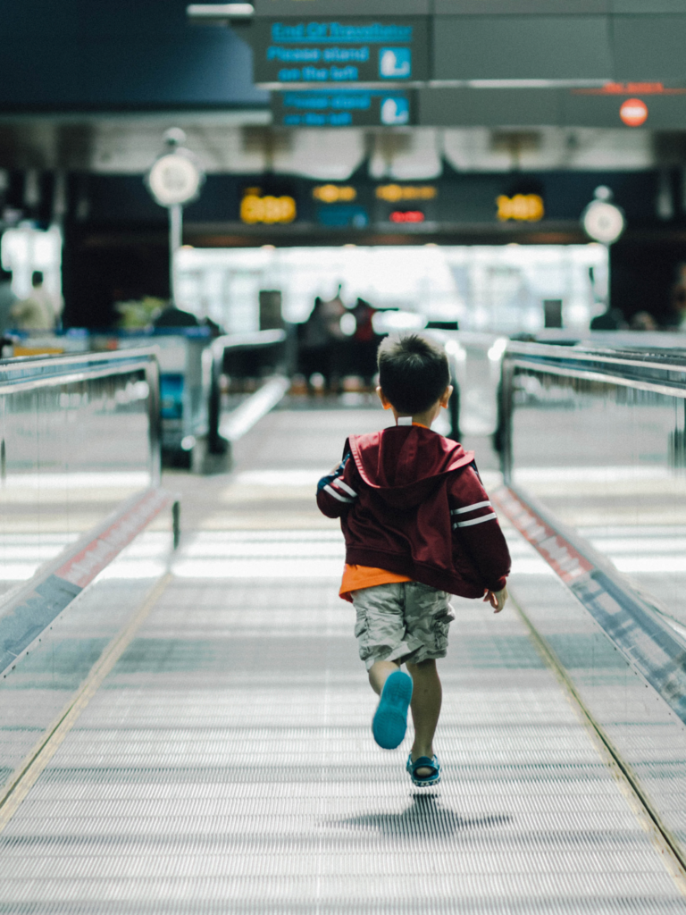 Young boy running through the airport for a leisure trip with family