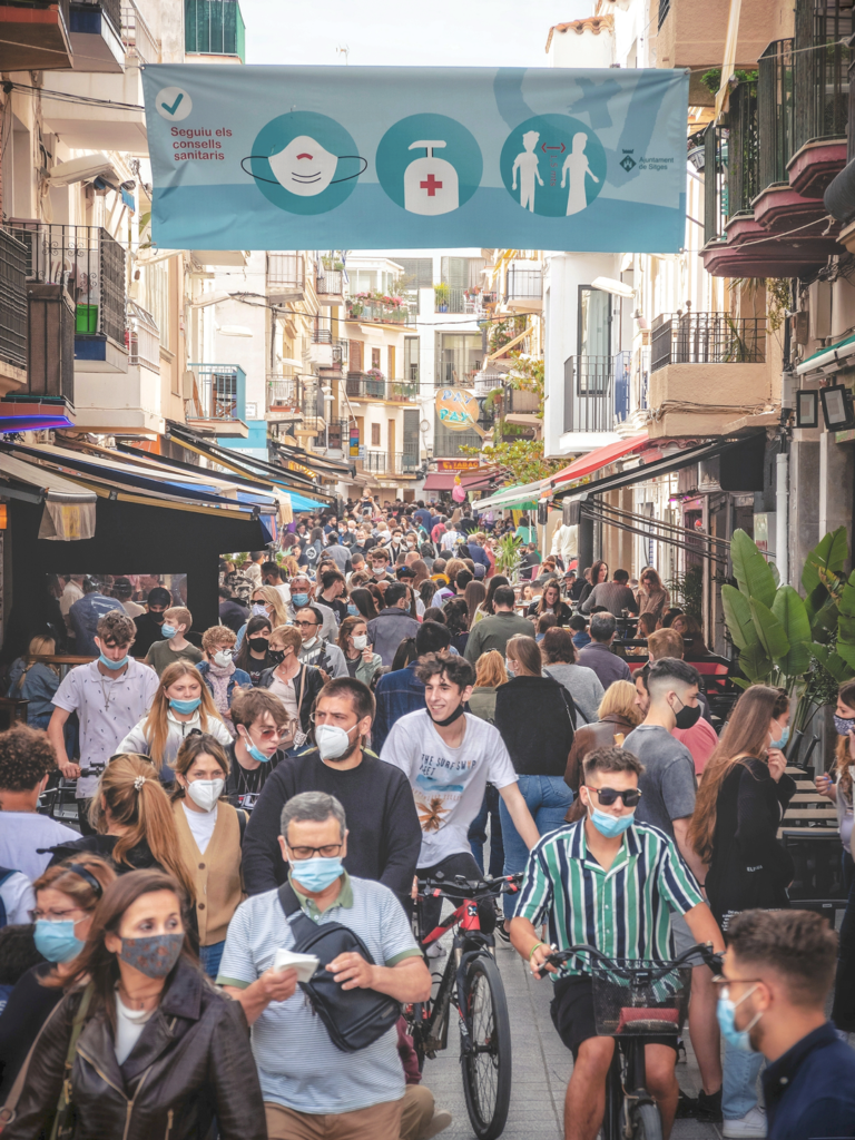 Crowd of travelers on a street wearing protective face masks.