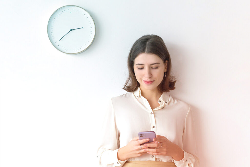 employees booking a flight on their phone - small business travel management