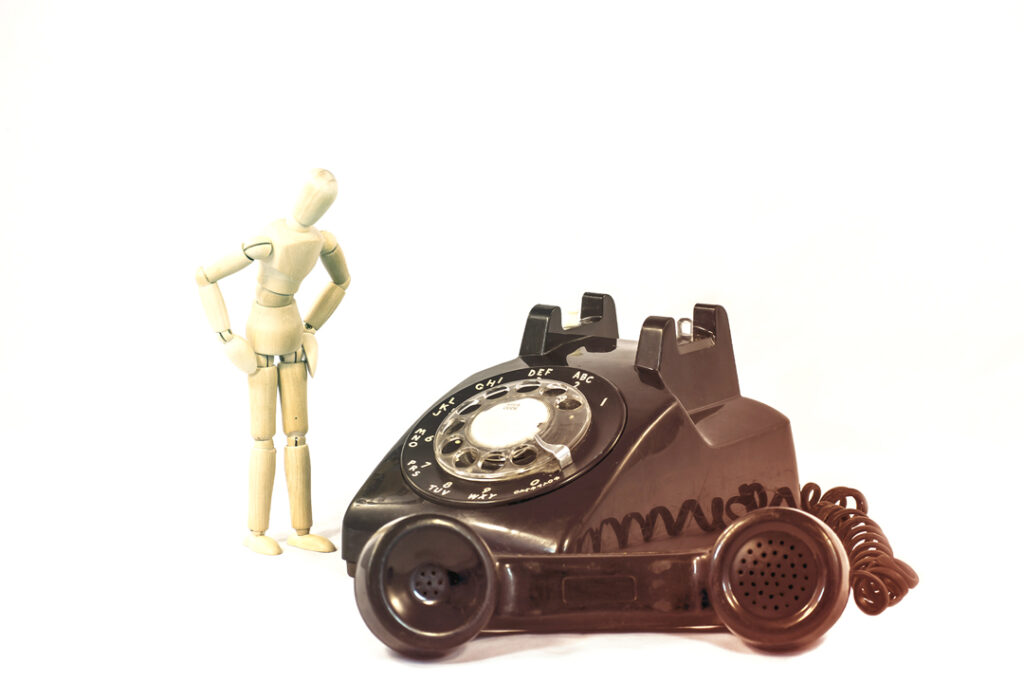 Old phone and wooden mannequin - Get Help Managing Travel