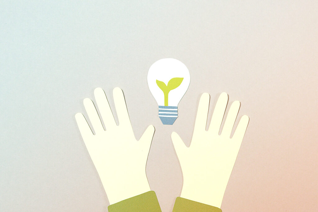 paper cut out of hand and a lightbulb