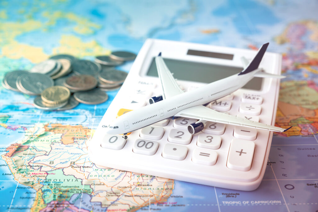 world map, calculator. coins and a toy plane