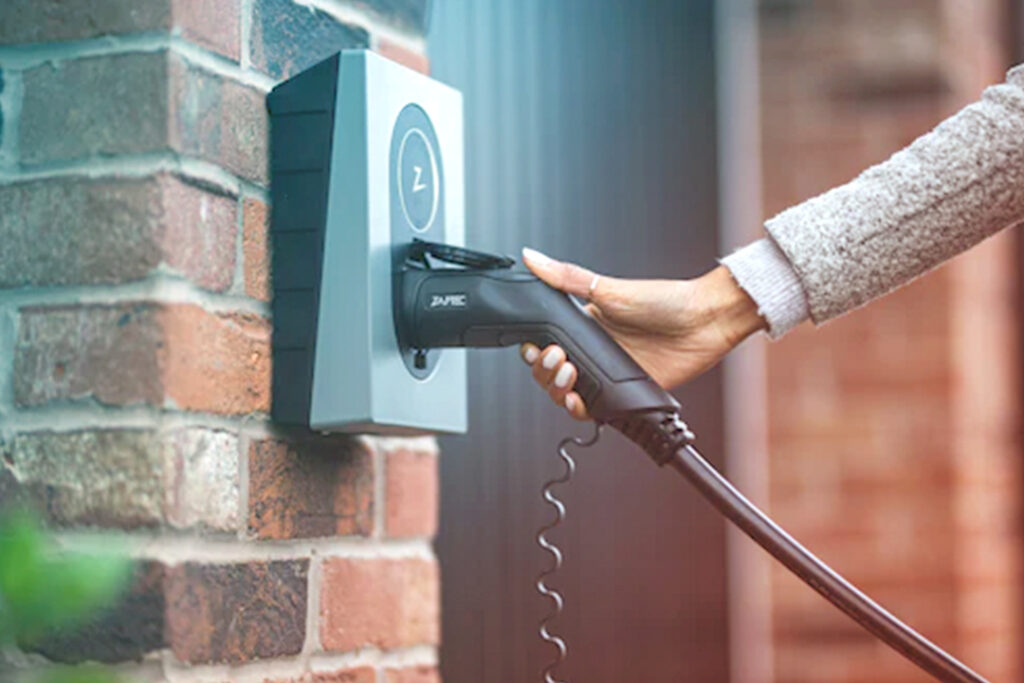 image of a woman charging her electric vehicle, car services and car rental agencies