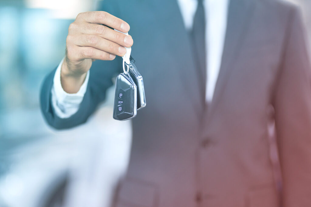 image of a hand reaching out holding a set of car keys