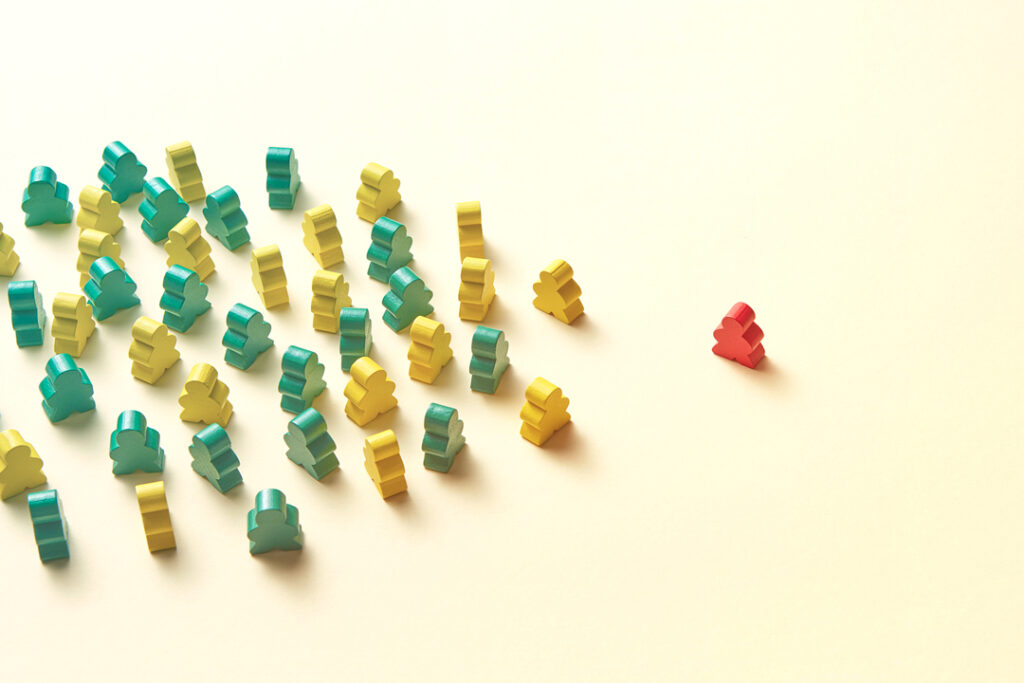 image of a group of small green and yellow block people and one red block person