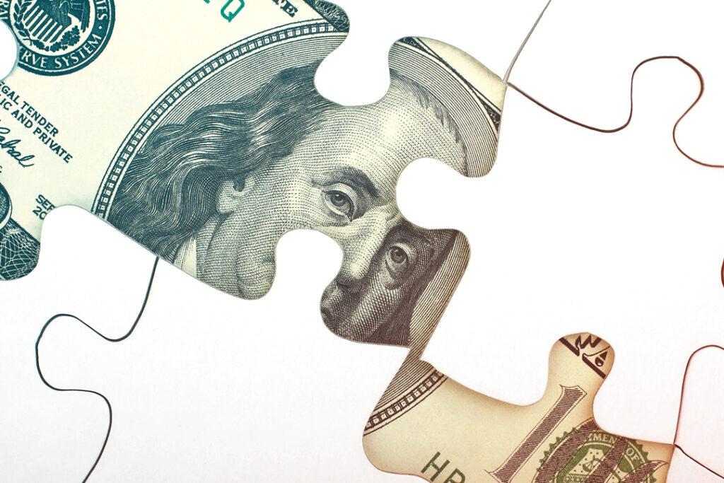 image of puzzle peaces making up a one hundred dollar bill - budget for business travel