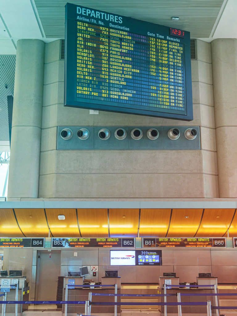 Image of an airport flight check in line and departure board