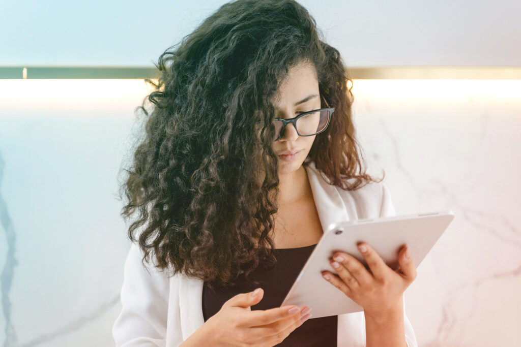 Image of a woman reading about business travel recovery on a tablet
