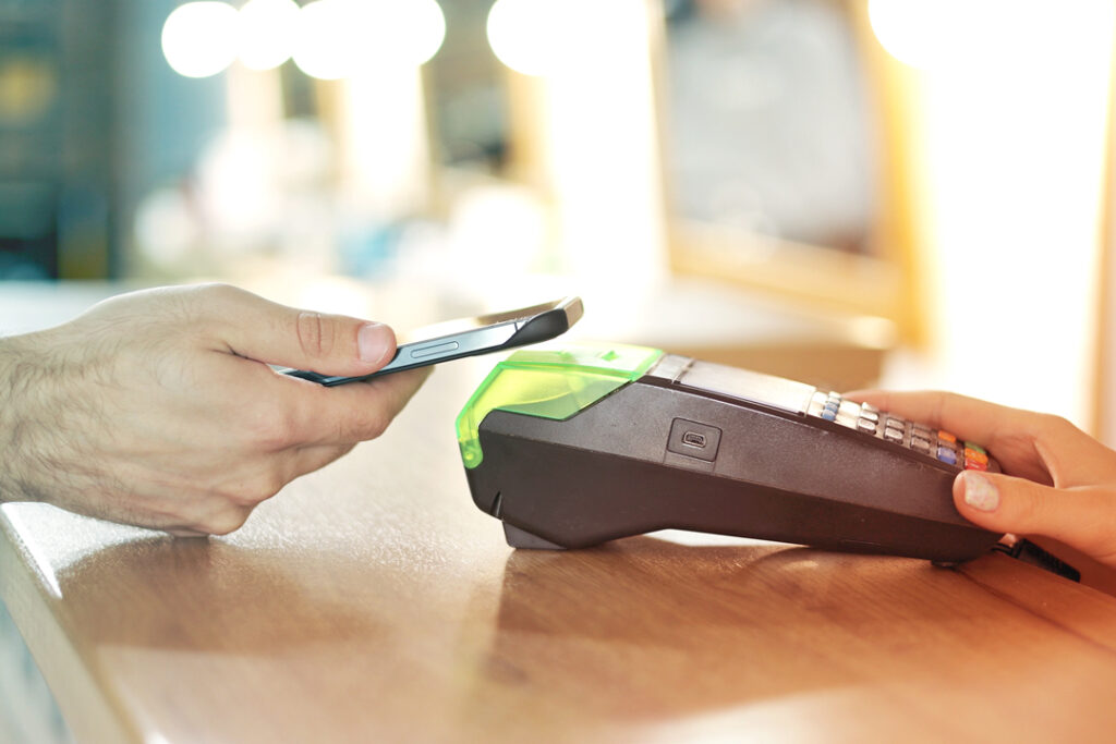 Image of someone paying with a tap to pay credit card.