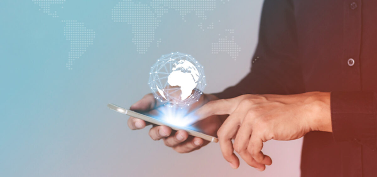 man holding a phone with a globe illustration over the phone indicating travel technology