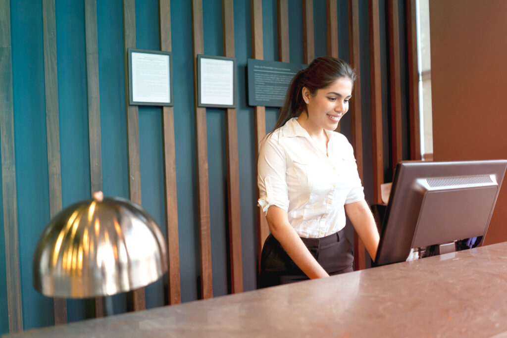 Image of a Hotel receptionist at their desk.