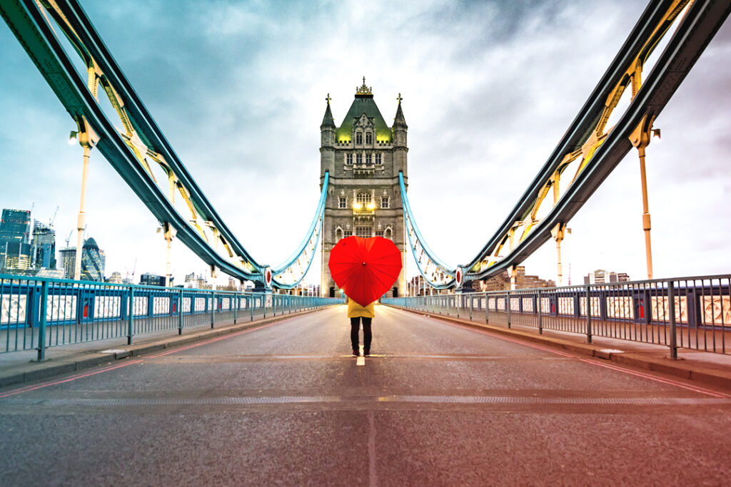 Image of a woman with a heart shaped umbrella on London Bridge Business Travel During Valentine’s Day
