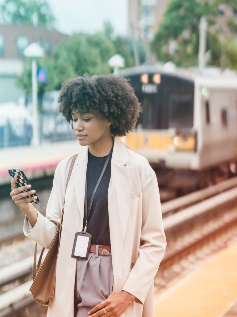 Image of a traveler on her phone while at a train station