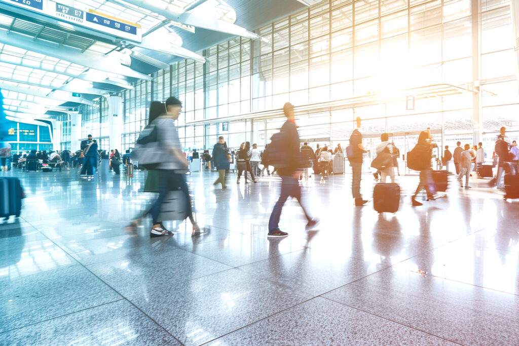 Image of a busy airport with travelers moving about