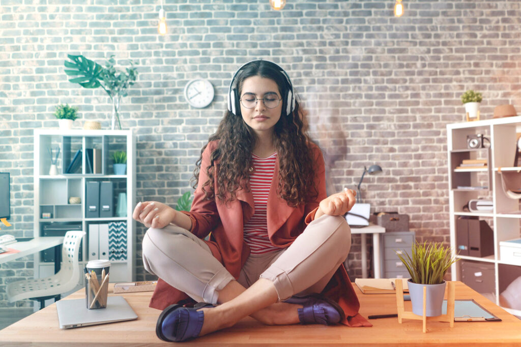 Image of a employee sitting on thier desk meditating