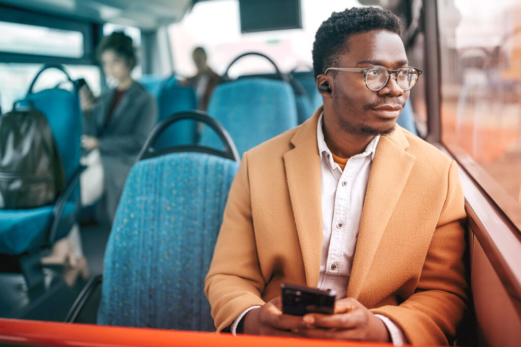 small business traveler on a train, talking with their office manager on the phone