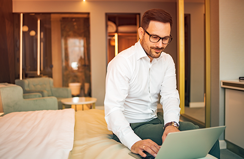 business traveler in hotel room on laptop