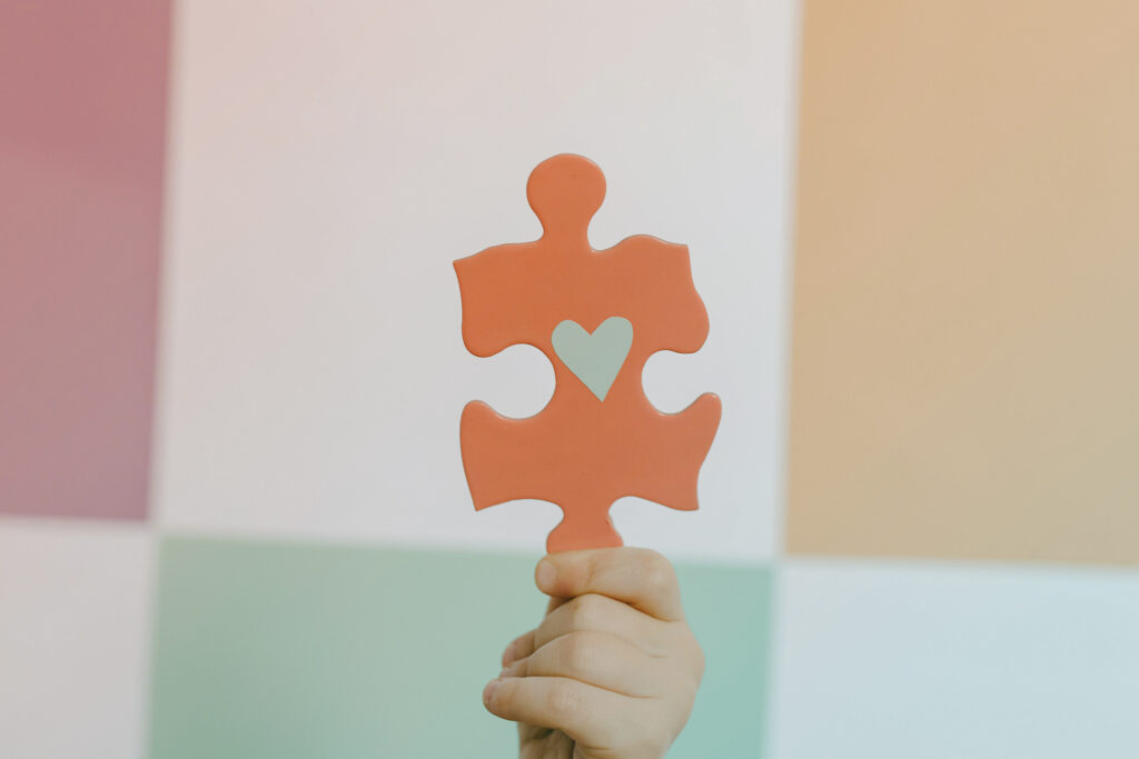 red puzzle piece with a blue heart in it
