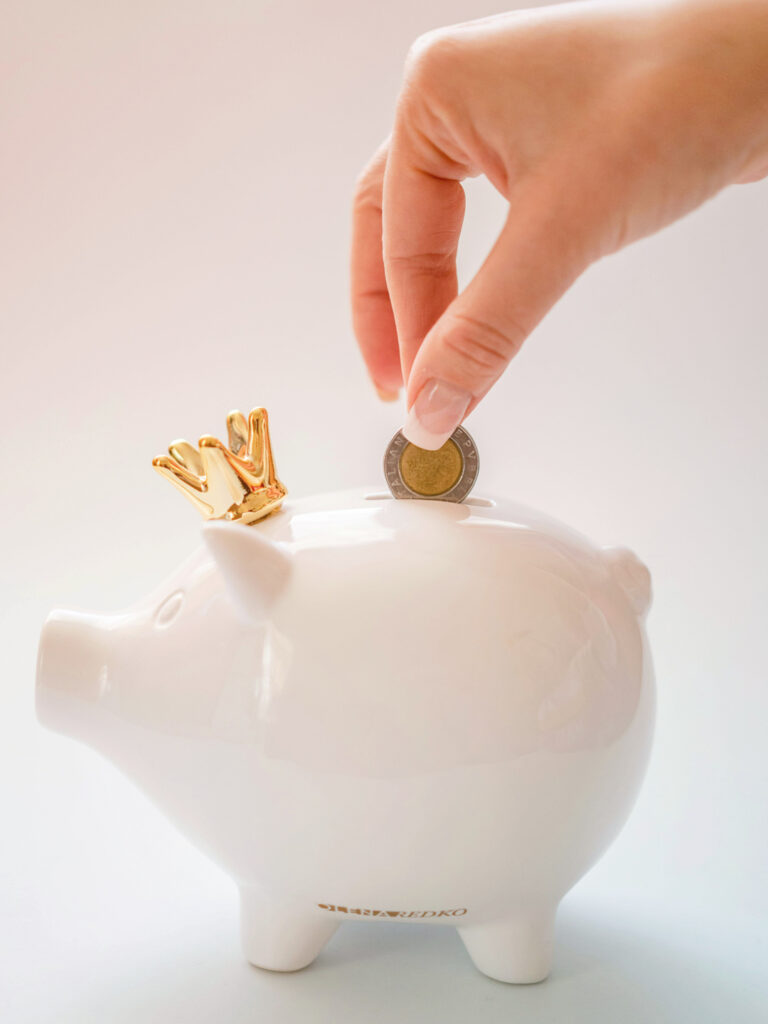 Adding a coin to a white piggy bank