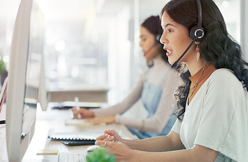 female travel advisor with headset at computer