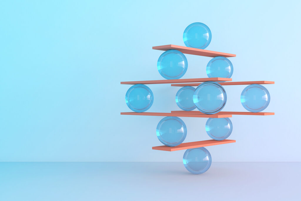 wooden planks and glass orbs balancing on each other demonstrating in-house travel management challenges