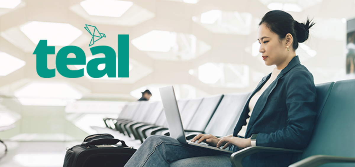 woman at the airport on a laptop with the Teal product logo