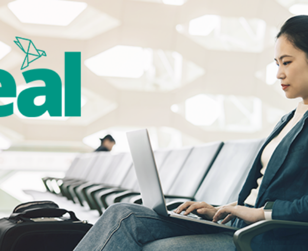 woman at the airport on a laptop with the Teal product logo
