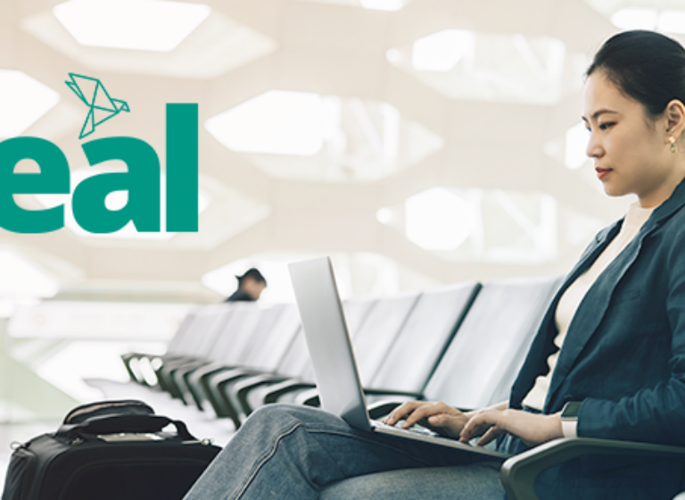 woman at the airport on a laptop with the Teal product logo