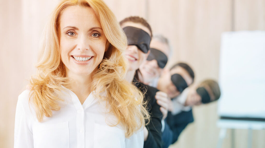 people with blindfolds on behind a smiling woman expressing Teal visibility
