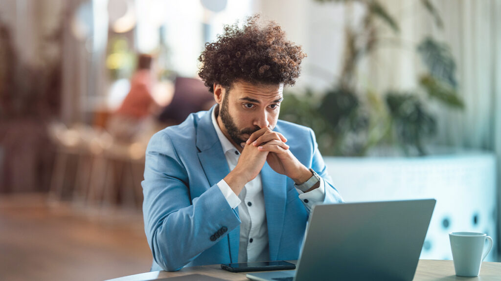 A Traveler looking at a computer worried about the duty of care in business travel risks