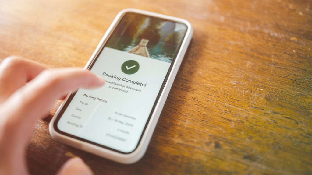 A traveler booking their own travel on their phone demonstrating travel leakage opportunities