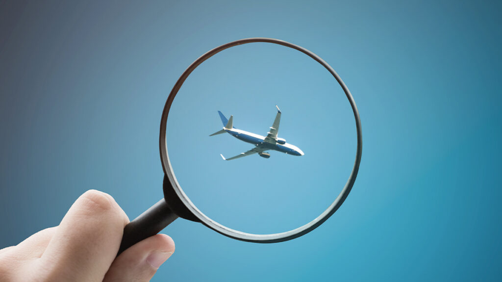 Magnifying glass with a plane in it, representing travelers searching outside the booking tool